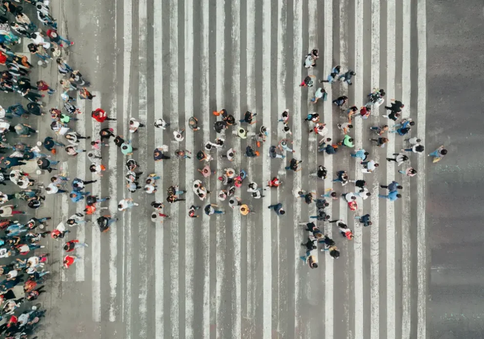 Drone view of people crossing the street in a right arrow formation