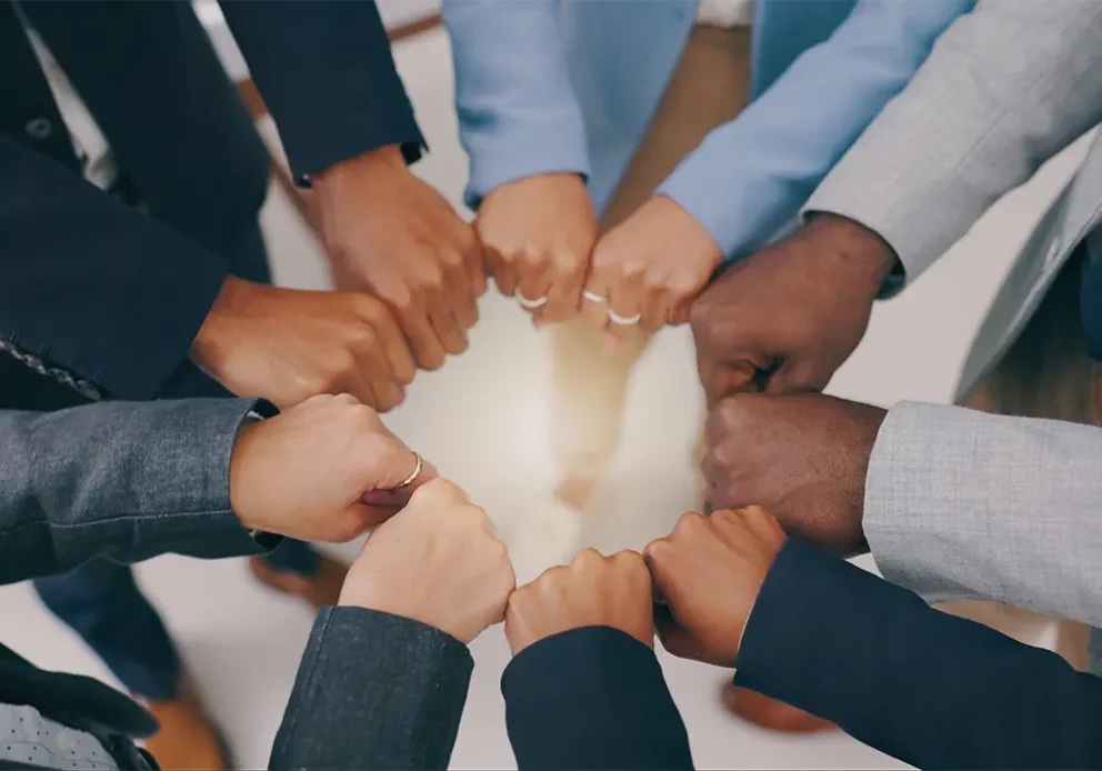 Closeup of business people, teamwork and fist of hands in circle for collaboration, synergy and motivation of global equality from above.