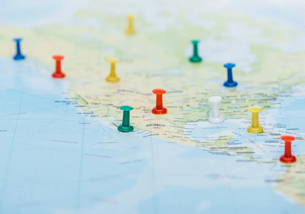 Selective focus of colorful push pins on world map with copy space.